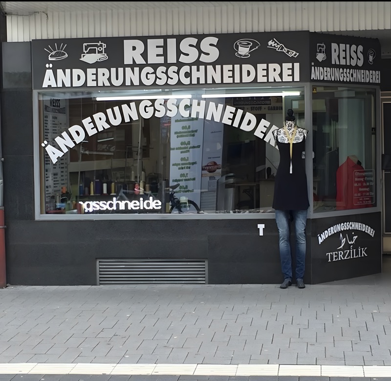 Fassade der Reiss Änderungsschneiderei mit schwarzem Schild in der Neusser Straße 47